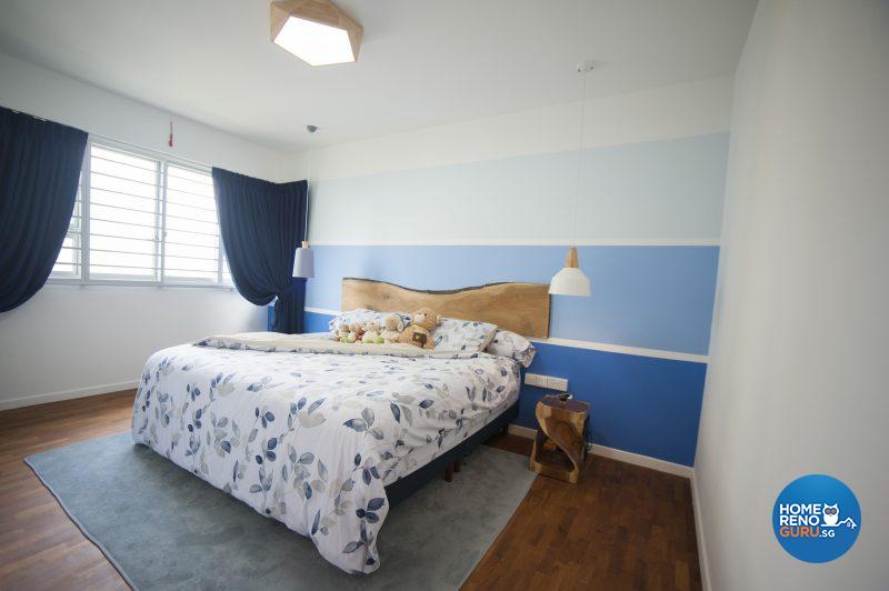 The cool, clean bedroom sports a feature wall in bands of blue