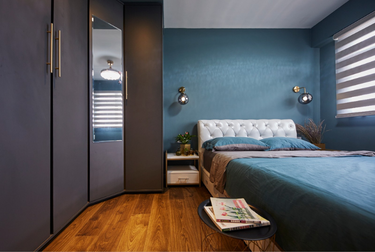 Bedroom with wardrobe and bed with dark green sheets