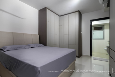 Bedroom with L-shaped wardrobe and bed with greyish-purple sheets