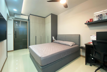 Bedroom with L-shaped wardrobe and bed with grey sheets