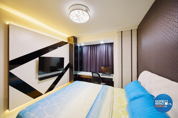 Bed with blue bedsheets, wall-mounted tv and tv panel with black bold lines