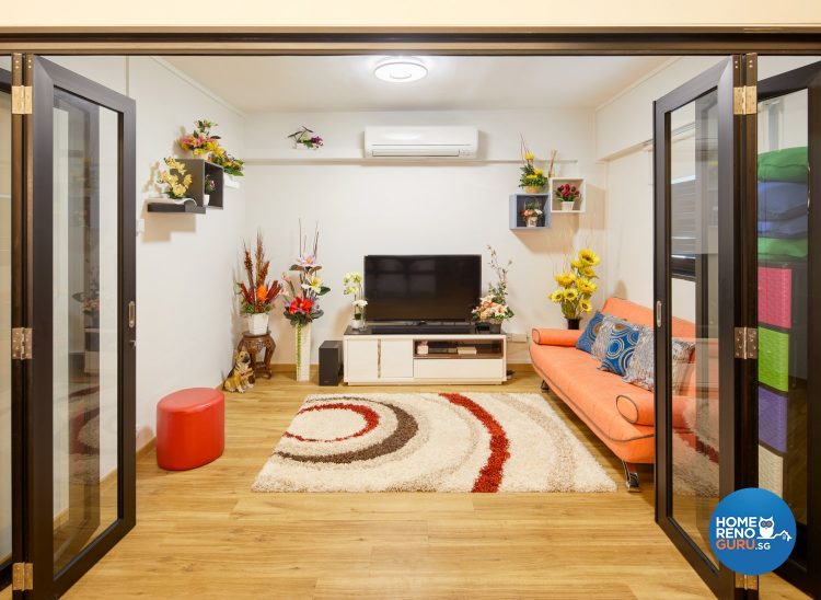 Rug with circle patterns, orange sofa, red stool and tv