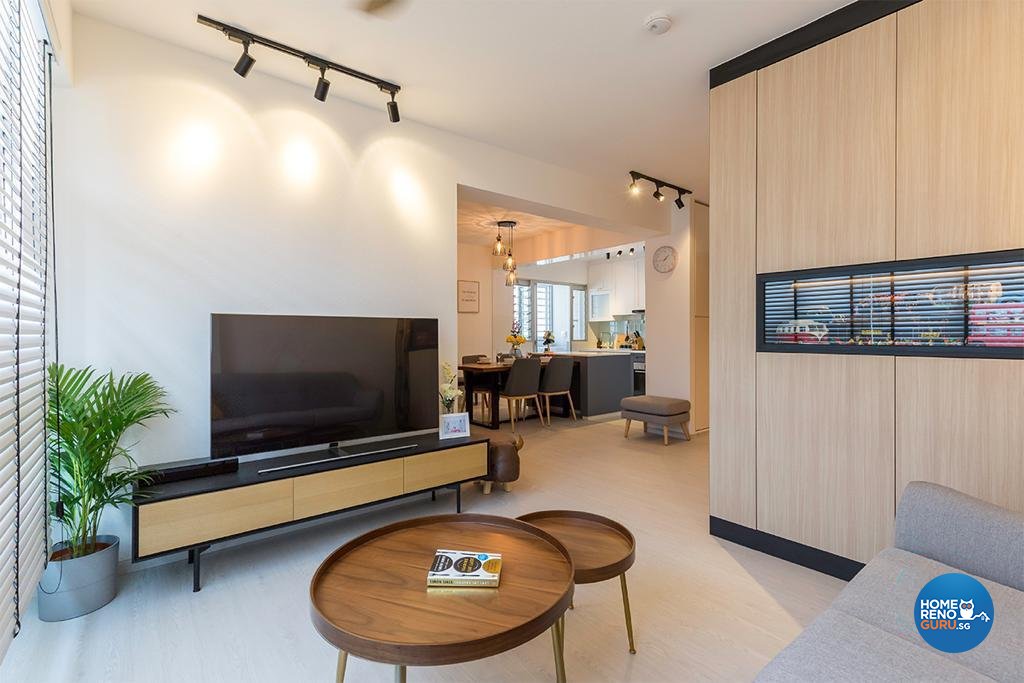 Circular, wooden coffee table, tv on tv console and brown wall