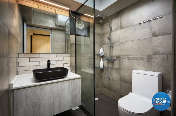 Black sink, white toilet bowl and glass partition