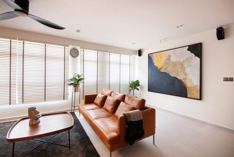 Living room with a brown leather sofa and painting