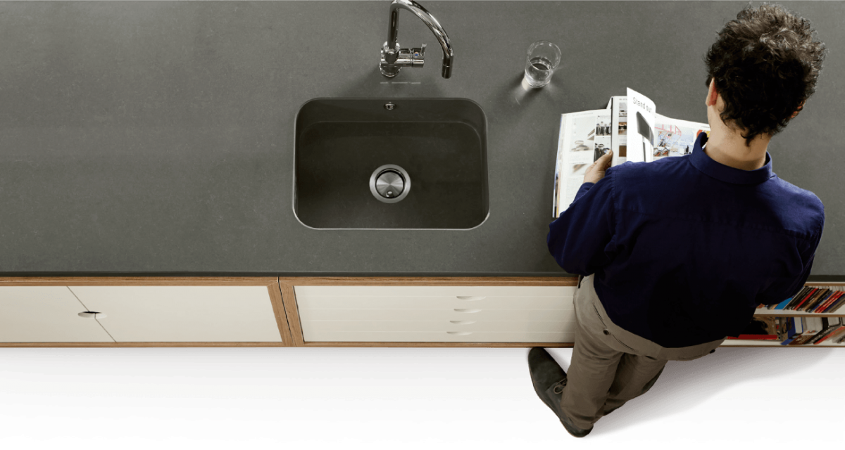 Man reading magazine at a Quartz kitchen countertop