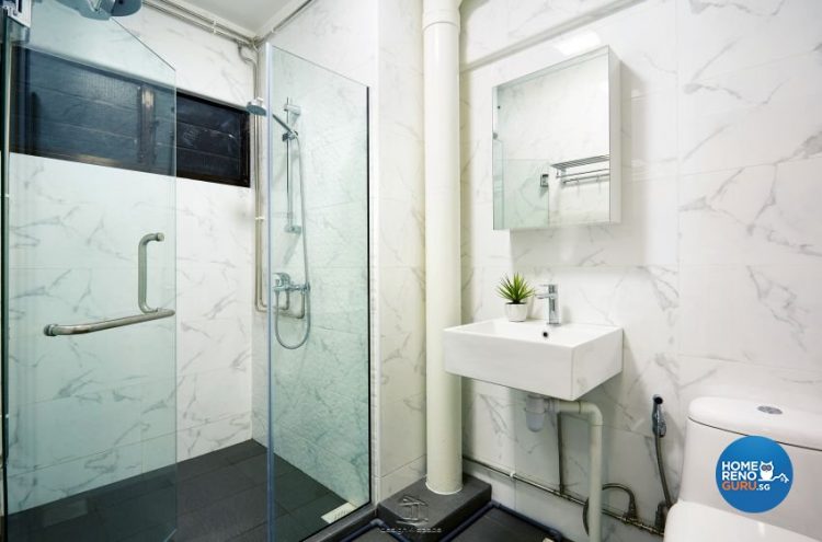 Toilet with a wall-mounted vanity and sink, with glass shower partition